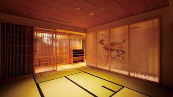 A traditional Japanese room with tatami flooring, sliding doors, and a wooden ceiling.
