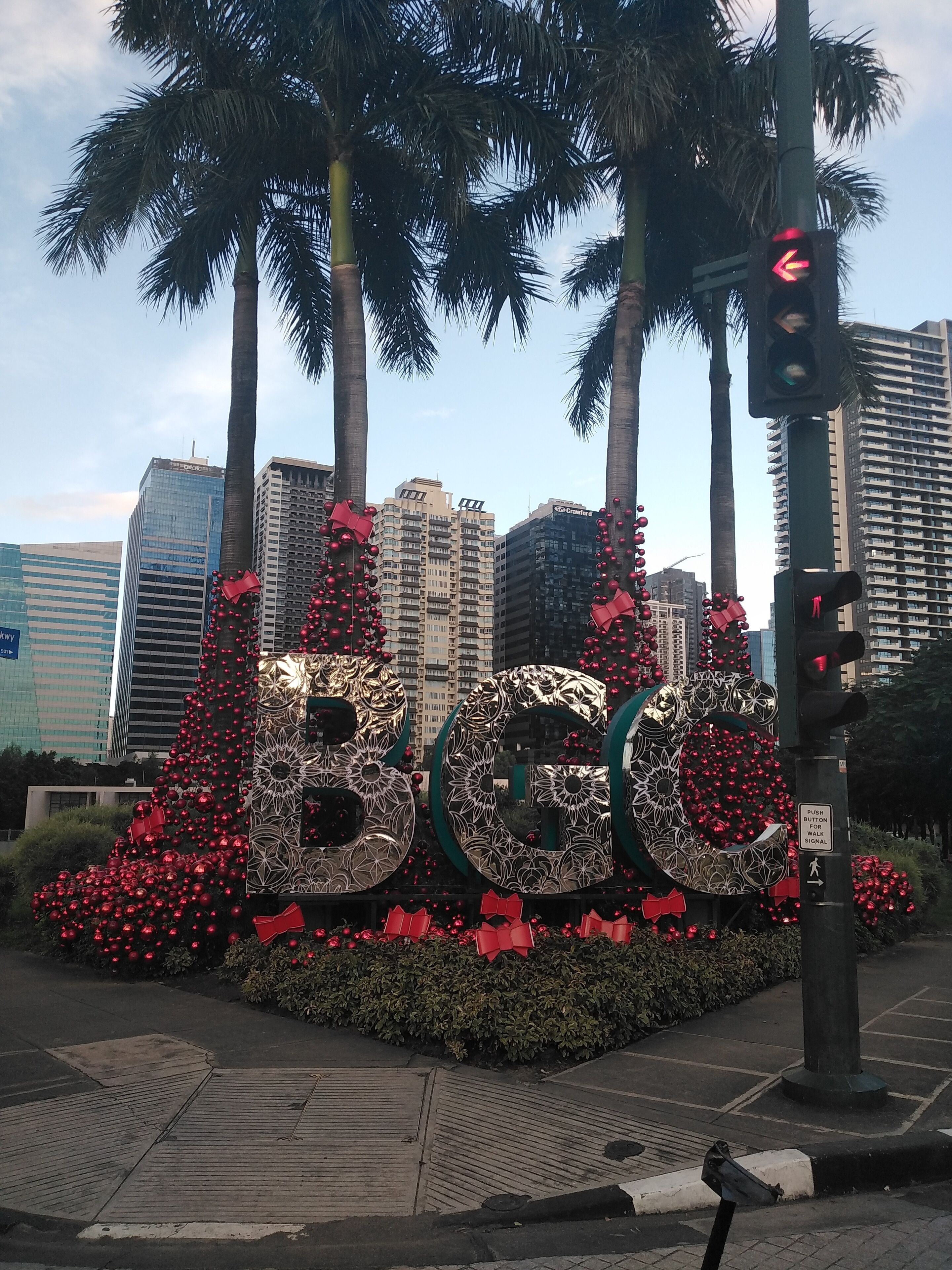 Una gran exposición al aire libre muestra el número '600' con adornos rojos, rodeada de palmeras y edificios en el fondo.