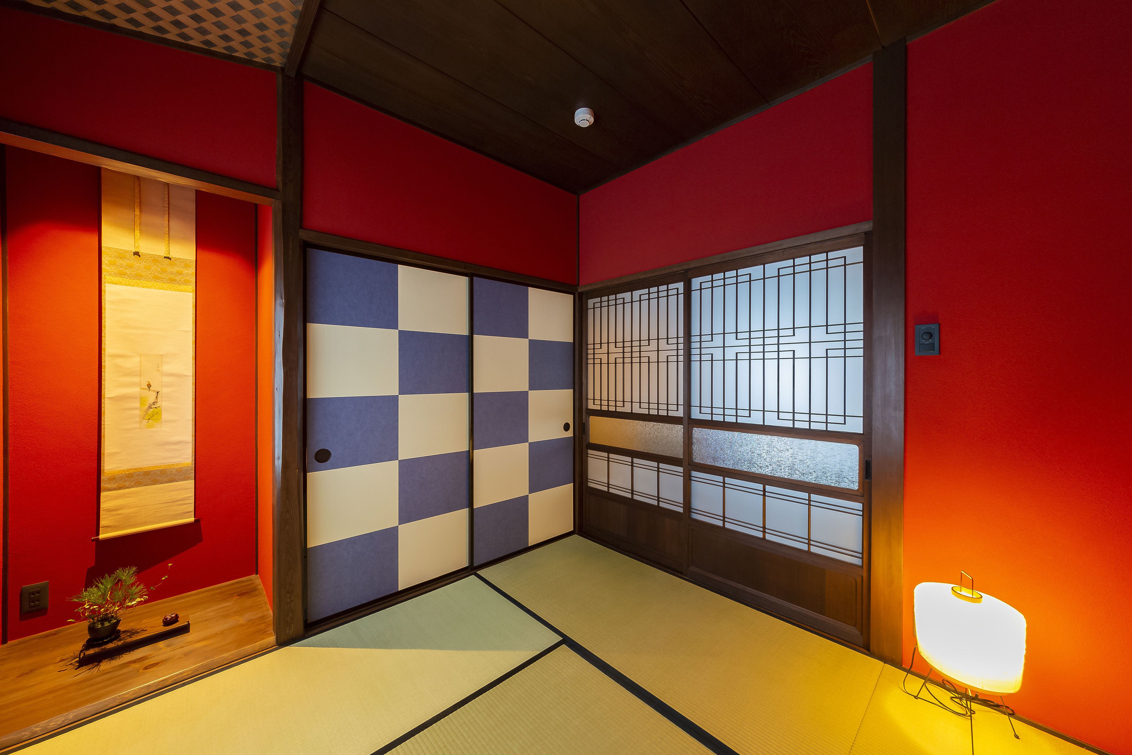 Um quarto japonês tradicional com tatames, porta de shoji e porta deslizante com padrão xadrez.