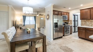 A modern kitchen with a central island, stainless steel appliances, and wooden cabinets.