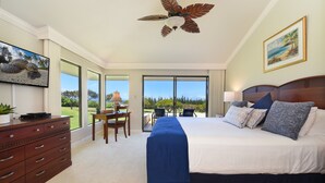 A spacious bedroom with a large bed, a ceiling fan, a desk, and a view of the outdoors. - SUMMER SPECIAL! Spacious Luxury 2 Bedroom Condo, Maui Sunsets! No Resort Fees! (Lahaina)