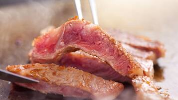 Ein Nahaufnahme von gegartem Fleisch, das mit einem Messer geschnitten wird.