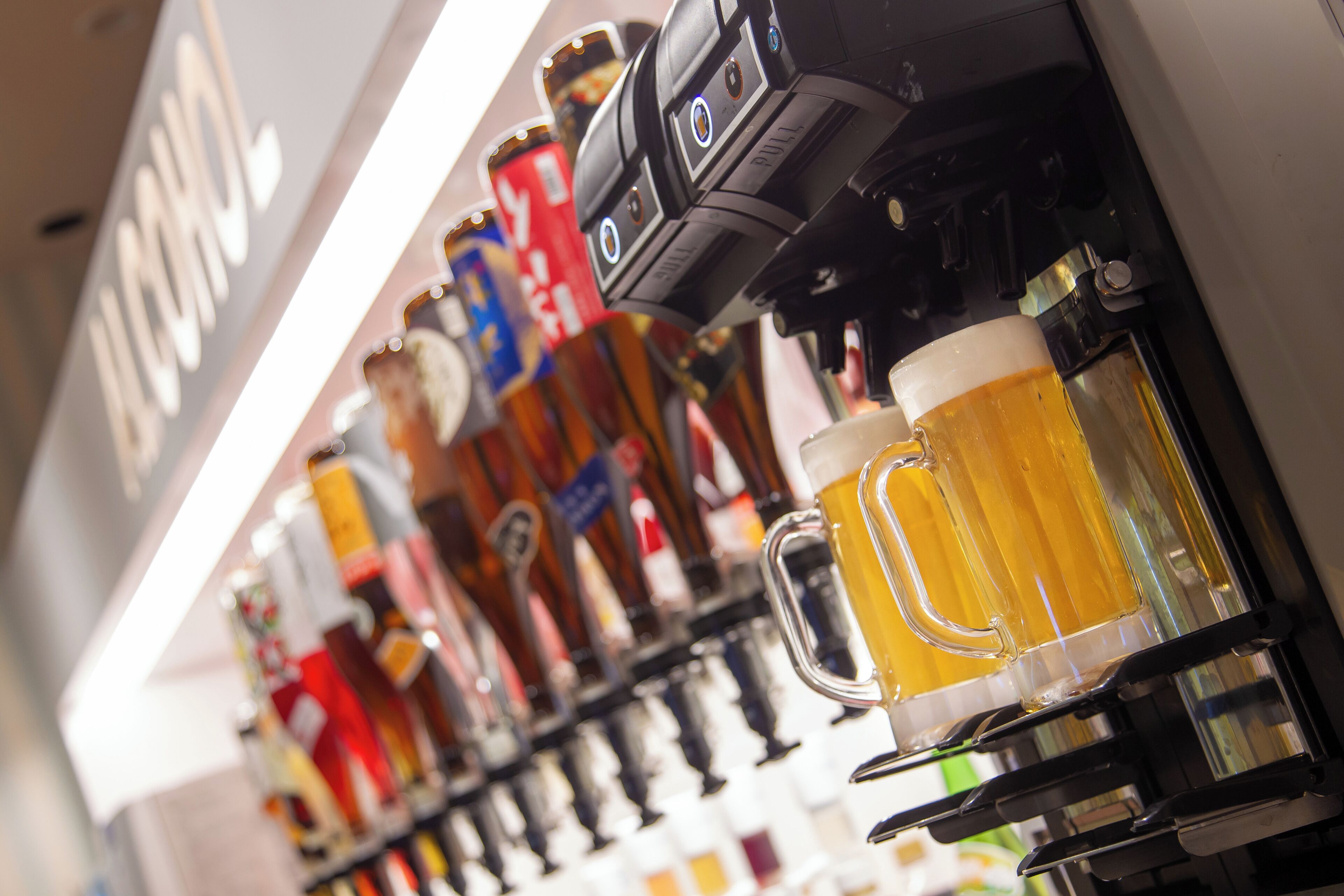 A bar with a variety of beer taps and mugs.