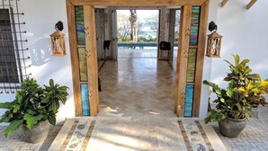 A spacious hallway with a wooden ceiling and a view of a swimming pool.