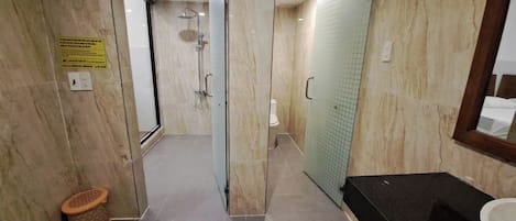 A modern bathroom with a glass shower enclosure, a toilet, and a sink area.