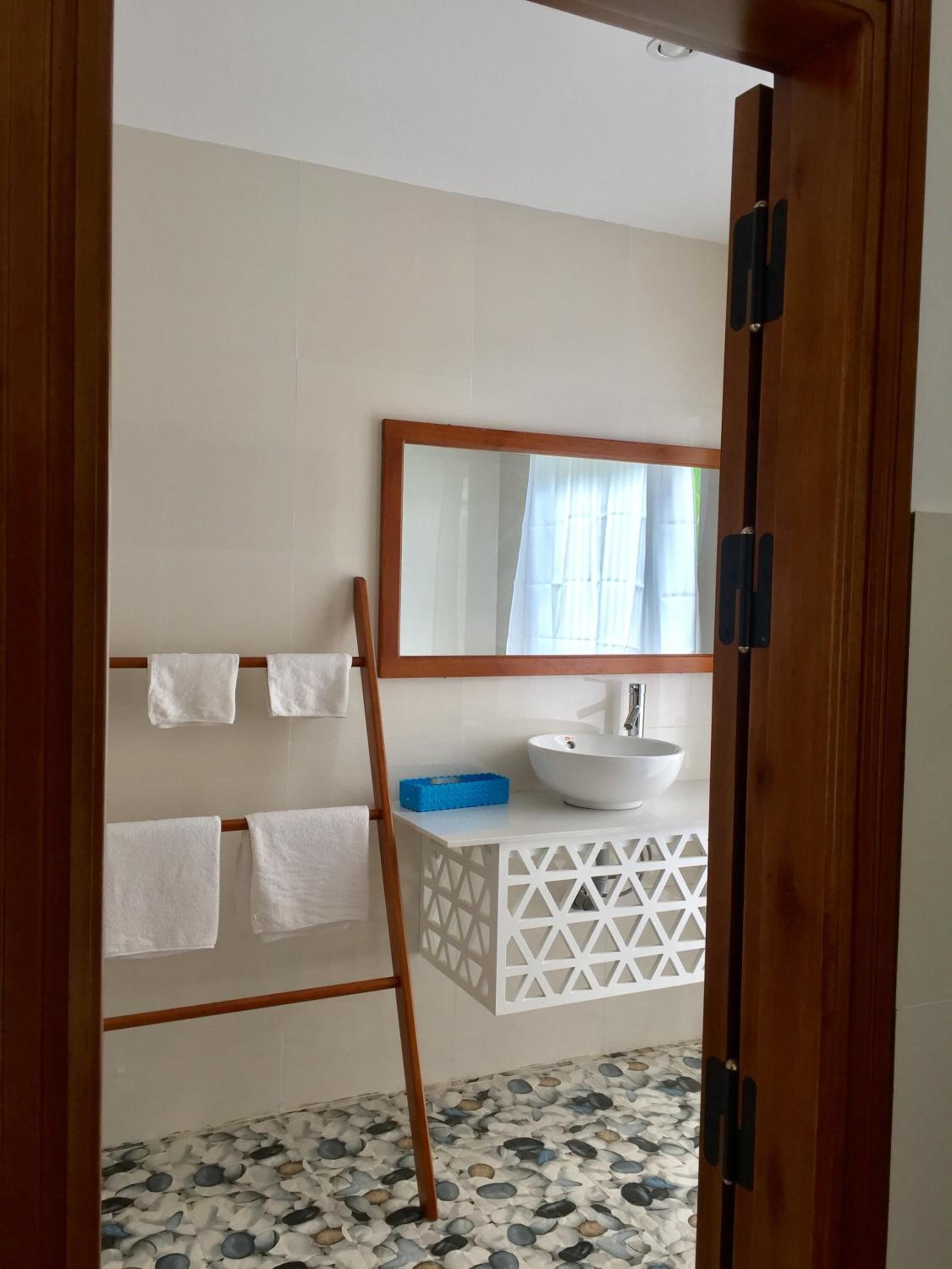 Ein Badezimmer mit Waschbecken, Spiegel und Handtuchhalter.