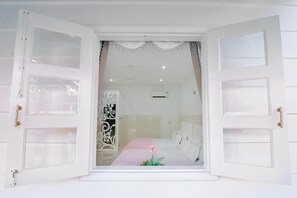 Una habitación con una cama, una mesita de noche y un adorno sobre la cama.