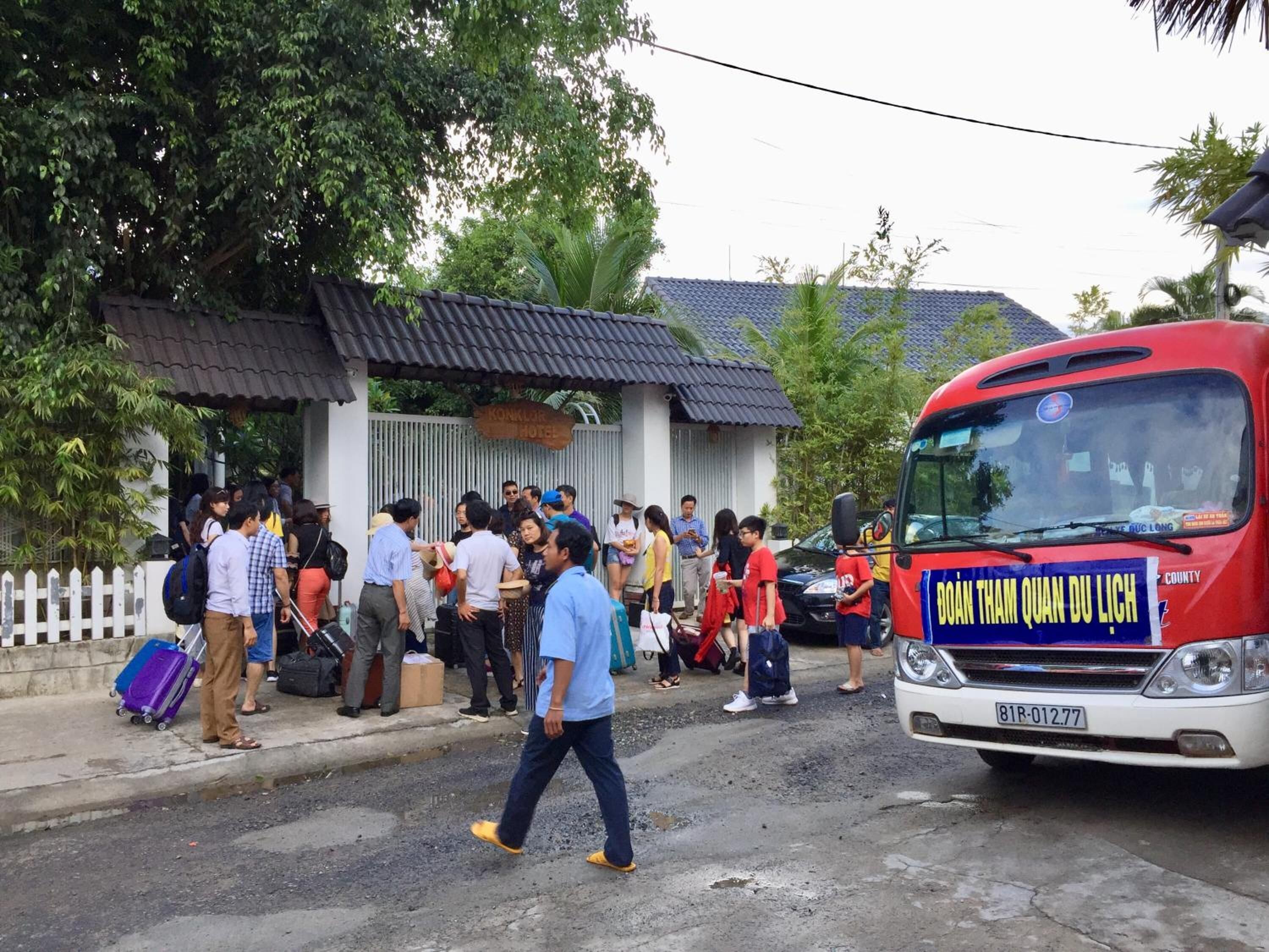 A group of people gathered outside a building with a sign that reads "KONKLOR HOTEL".