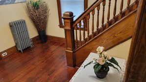 A wooden staircase with a radiator and a potted plant on the landing. - COZY HOME- Located on a quiet Worthy Street with a home in its own compound. (Springfield)