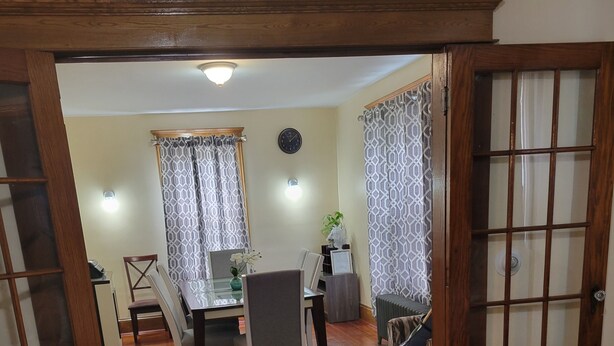A living room with a sofa, a coffee table with a vase, and a dining area with a table and chairs. - COZY HOME- Located on a quiet Worthy Street with a home in its own compound. (Springfield)