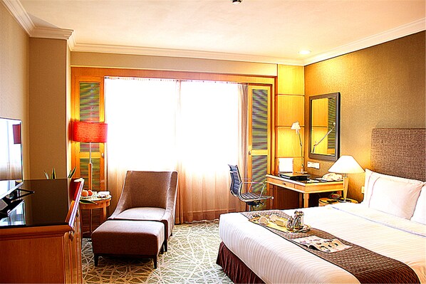 A hotel room with a bed, a desk, a chair, a TV, and a window with curtains. - Grand Park Wuxi (Wuxi)
