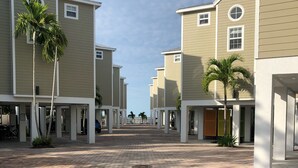 A row of modern, two-story buildings with a paved walkway in between.