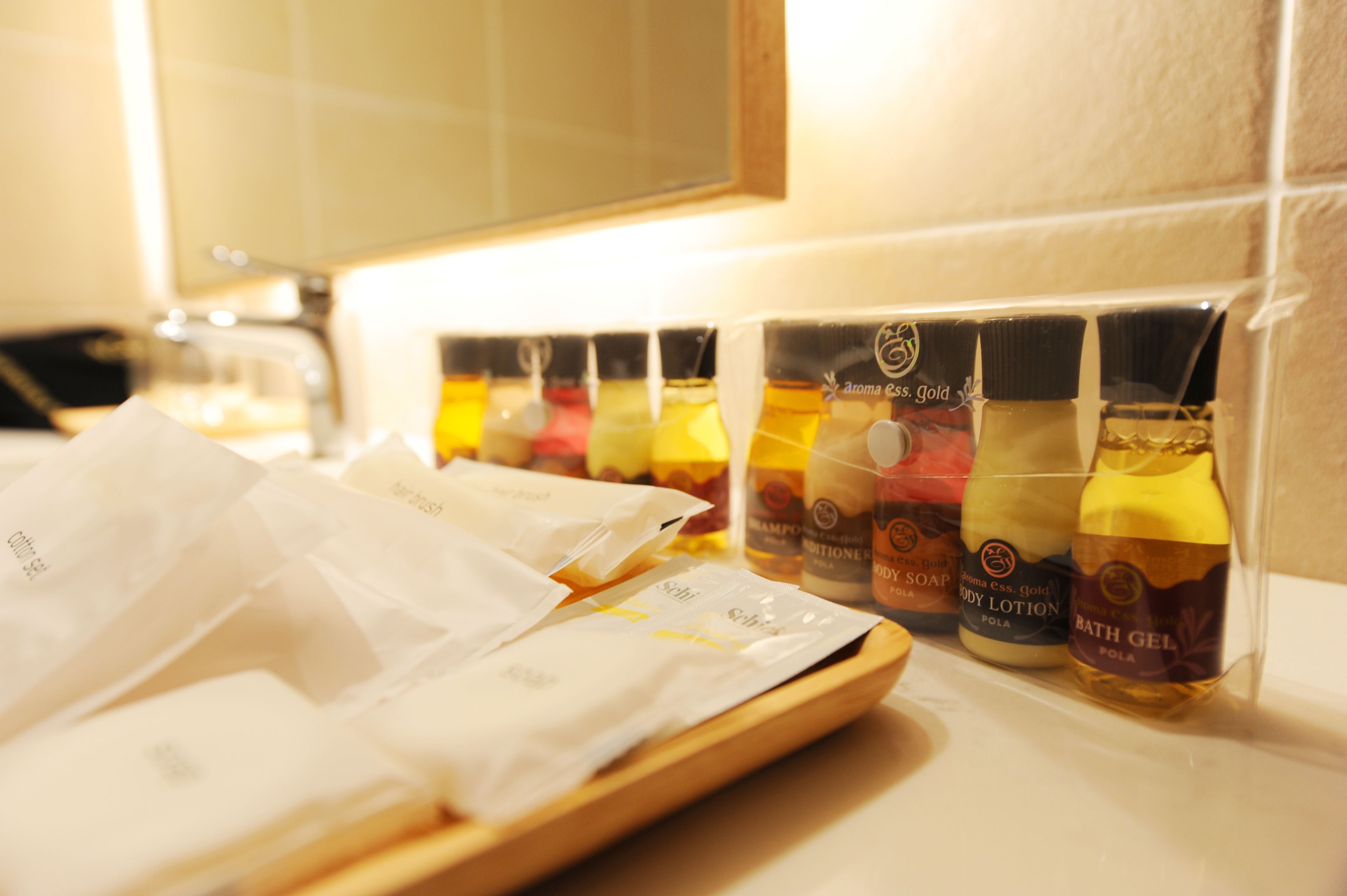 A bathroom counter with various toiletries including shampoo, conditioner, body lotion, and bath gel.