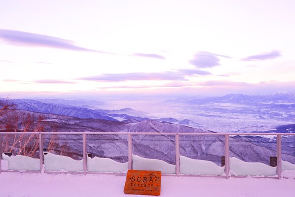 Un paysage enneigé avec un panneau indiquant « Terrasse de SORA » et « Altitude : 5 770 m ».