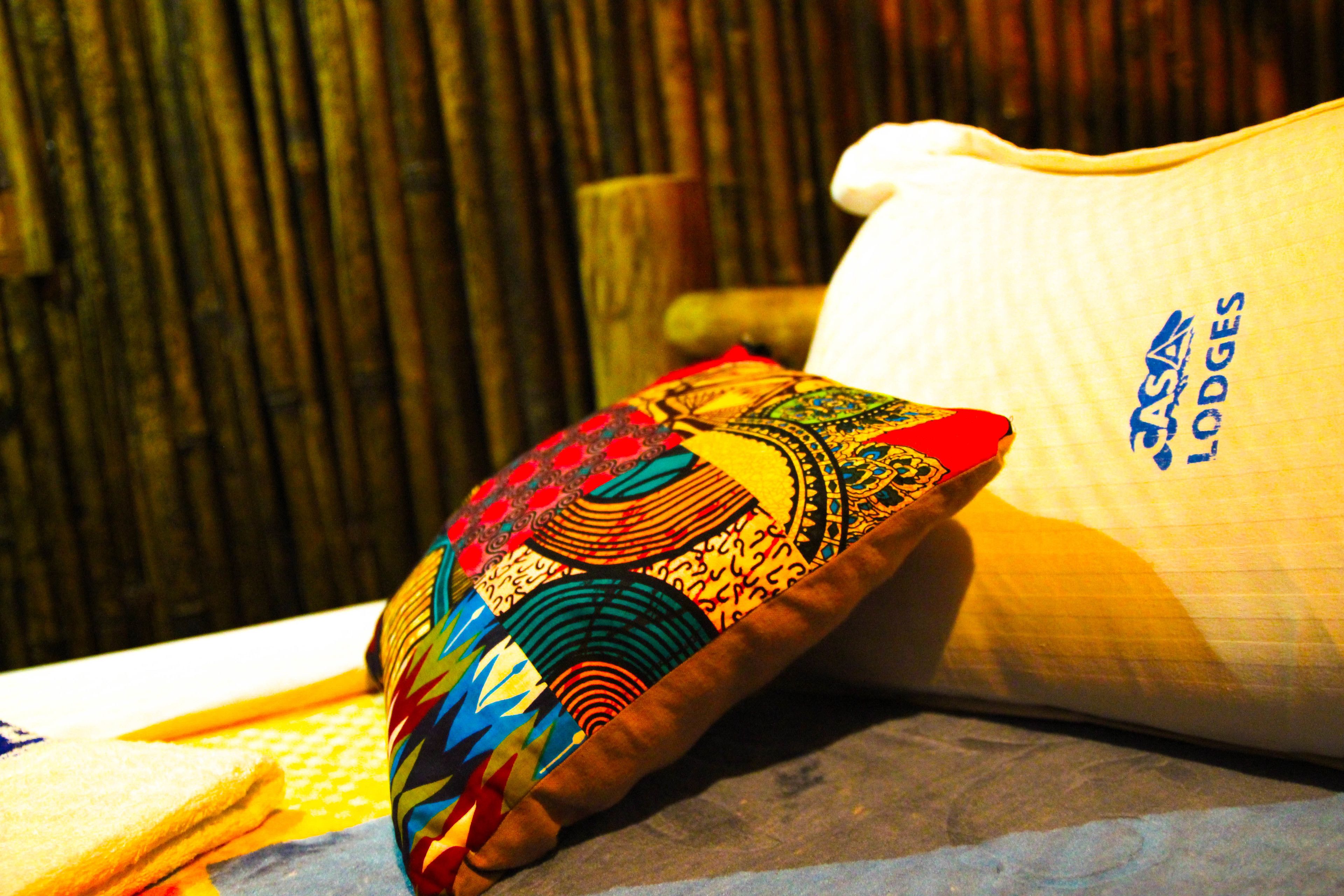 A pillow with a colorful pattern and a white pillow with text.