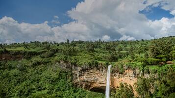 Paisagem verdejante com uma cascata descendo por um penhasco.