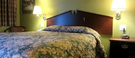 Une chambre d’hôtel avec un lit, deux lampes de chevet, une table de chevet et une chaise.
