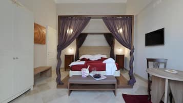 Una camera da letto con un letto, comodini, una TV e un'area pranzo.