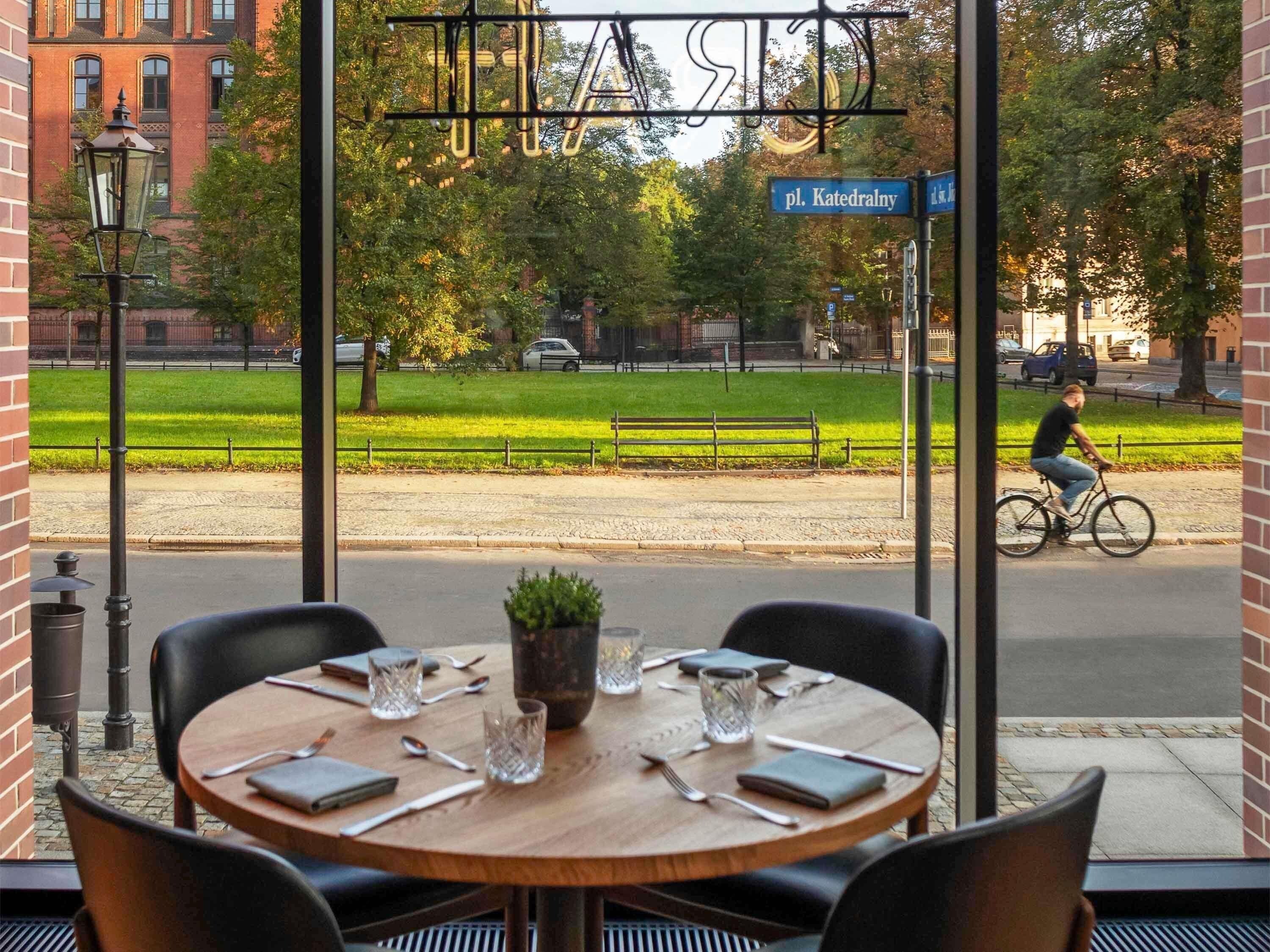A restaurant with a view of a street and a cyclist.