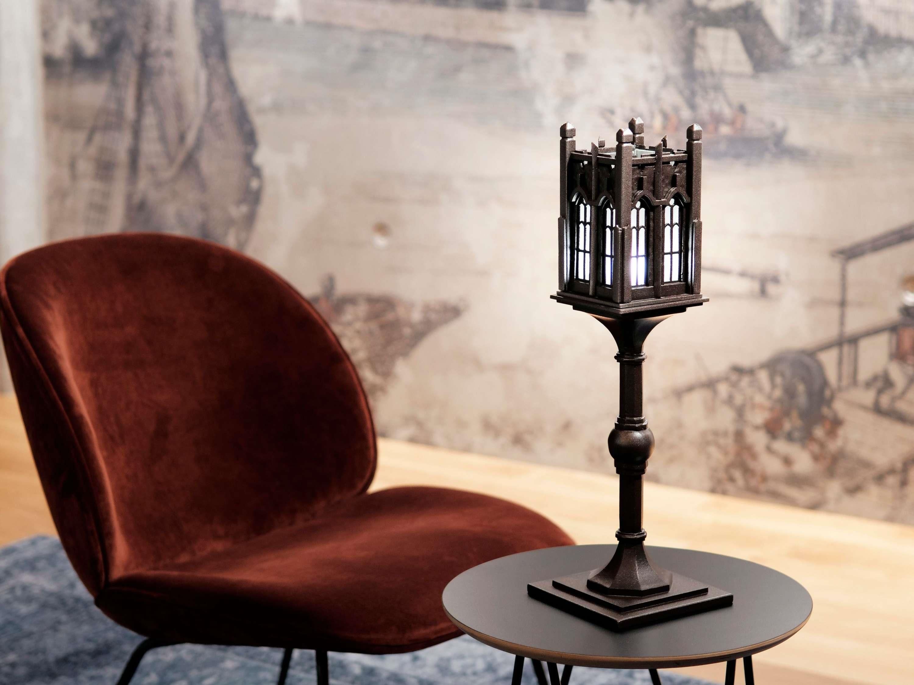 Una habitación con una mesa redonda, una silla y un objeto decorativo que parece una linterna.