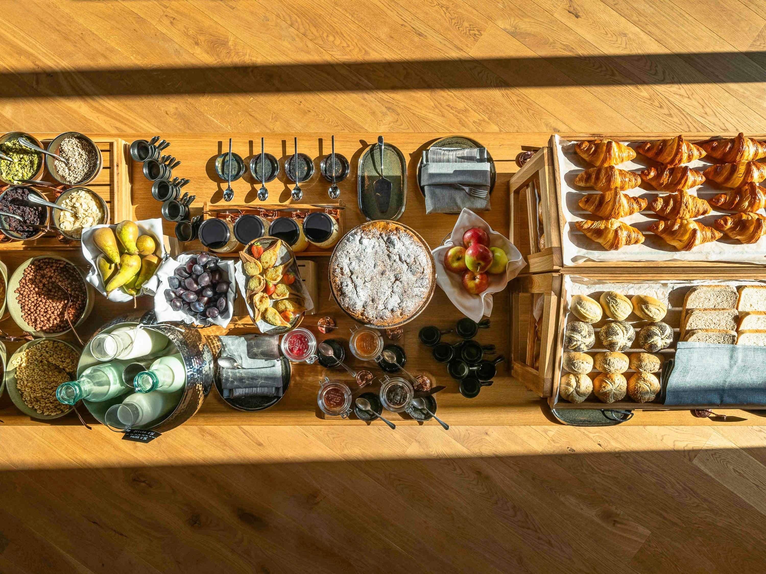 A wooden table with various food items and kitchen utensils.
