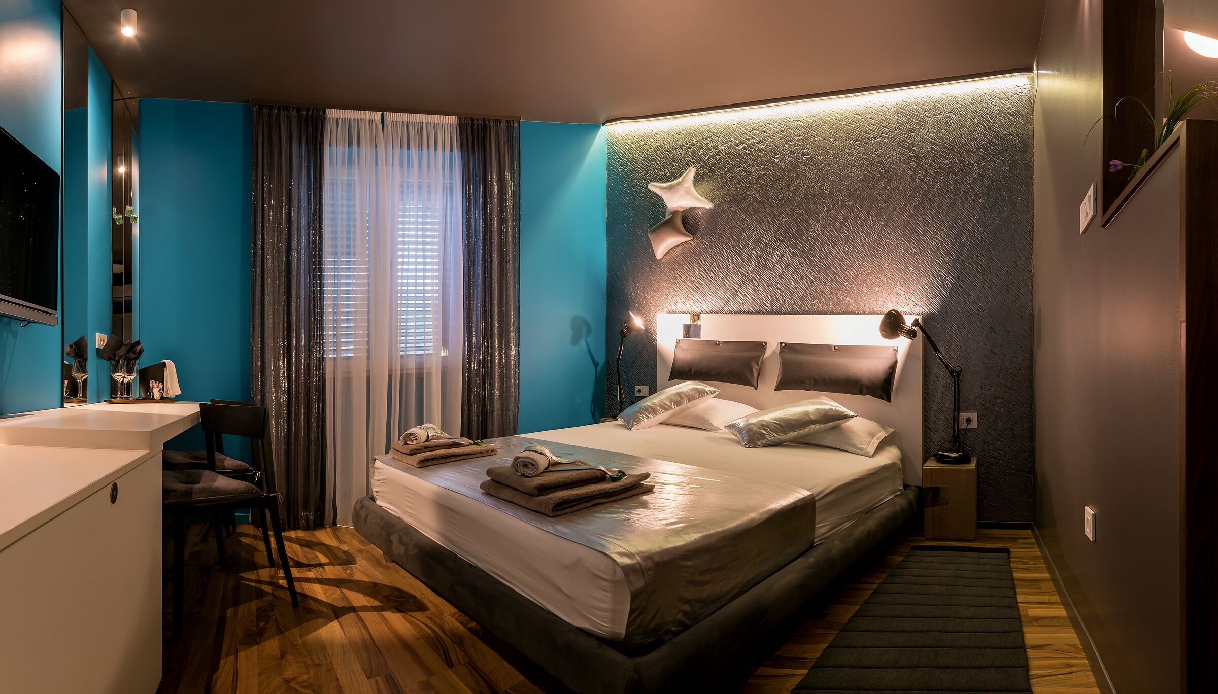Une chambre d’hôtel moderne dotée d’un grand lit, d’un bureau et d’un espace douche.