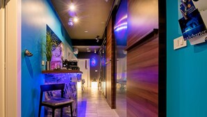 Un pasillo con mostrador de recepción, una silla y una puerta de madera.