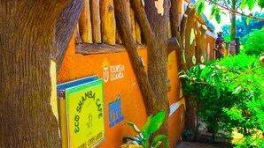 Un mur sur lequel on peut voir une enseigne « Tourism Uganda », une enseigne « Shamba Caffes » et le logo UTMB.