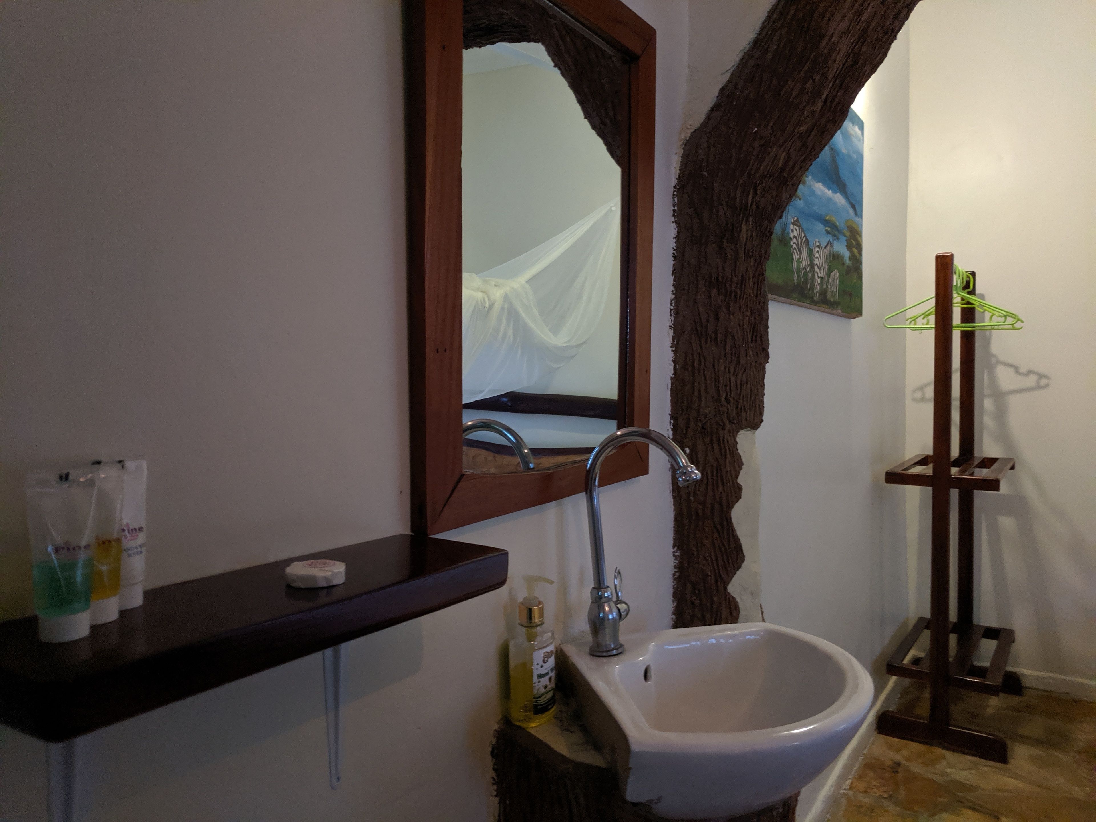 A bathroom with a white sink, a mirror, and a towel rack.