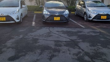 Een parkeerplaats met drie auto's op een rij.