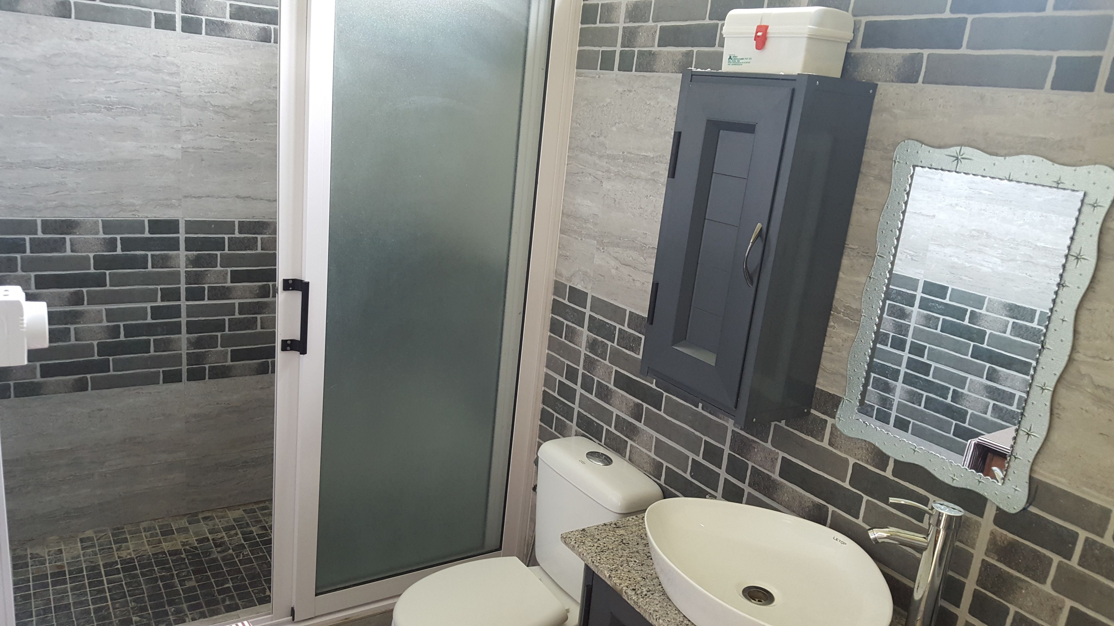 A bathroom with a shower, toilet, and sink.
