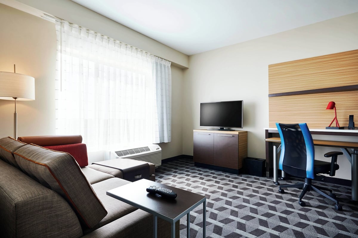 Une chambre d’hôtel équipée d’un canapé, d’une télévision, d’un bureau et d’une chaise.