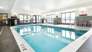 Une piscine intérieure à l’eau claire, avec des repères indiquant la profondeur et un panneau indiquant qu’il est interdit de plonger.