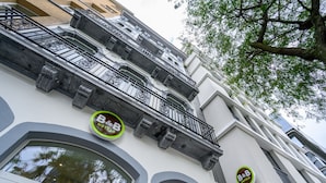 A hotel facade with ornate balconies and large windows.