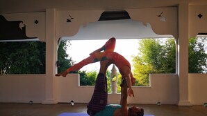 A yoga mat on the floor with a person performing a handstand. - Amaravati Wellness Center and Resort (Mae Rim)