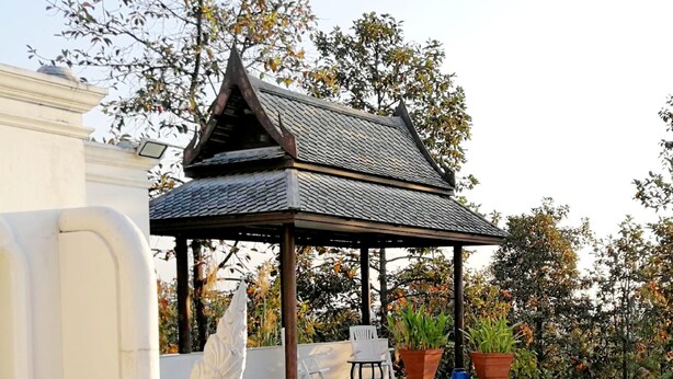 A pool with a pagoda-style gazebo, a swan sculpture, and potted plants. - Amaravati Wellness Center and Resort (Mae Rim)