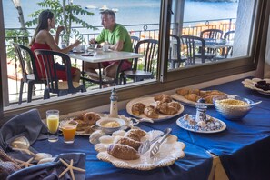A dining table with breakfast items and a view of the ocean. - Villaggio Innamorata - Villa Quintavalle (Capoliveri)
