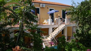 A two-story building with a balcony, outdoor seating, and a staircase. - Villaggio Innamorata - Villa Quintavalle (Capoliveri)