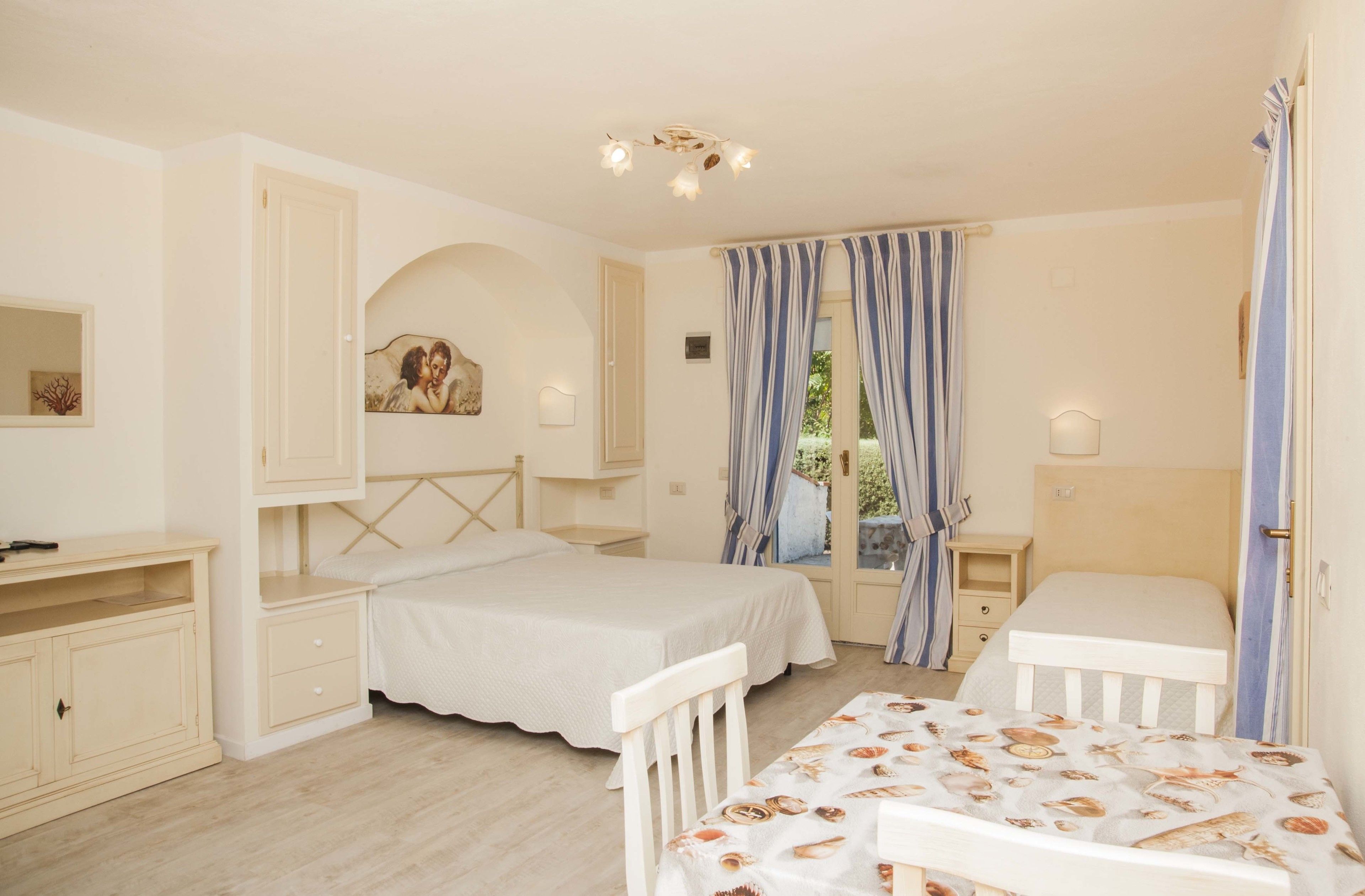 Ein Schlafzimmer mit einem Bett, einem Schreibtisch, einem Stuhl, einem Kleiderschrank und einem Fenster mit Vorhängen.