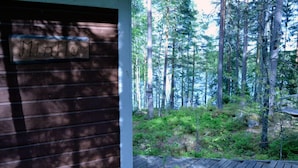 A wooden cabin with a sign reading "MINTTE" and a view of a forested area with a wooden deck. - Salkolahti Minttu (Orivesi)