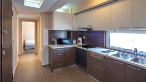 Una cocina moderna con armarios de madera oscura, un microondas integrado y una ventana sobre el fregadero.