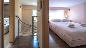 Habitación de hotel con cama, lámpara de noche, teléfono y ventana.