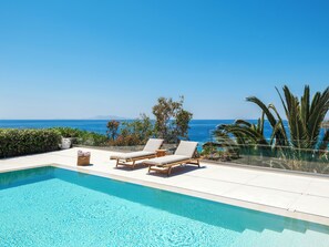 A pool with lounge chairs and a view of the ocean. - myMykonos Villa 1 (Mykonos)