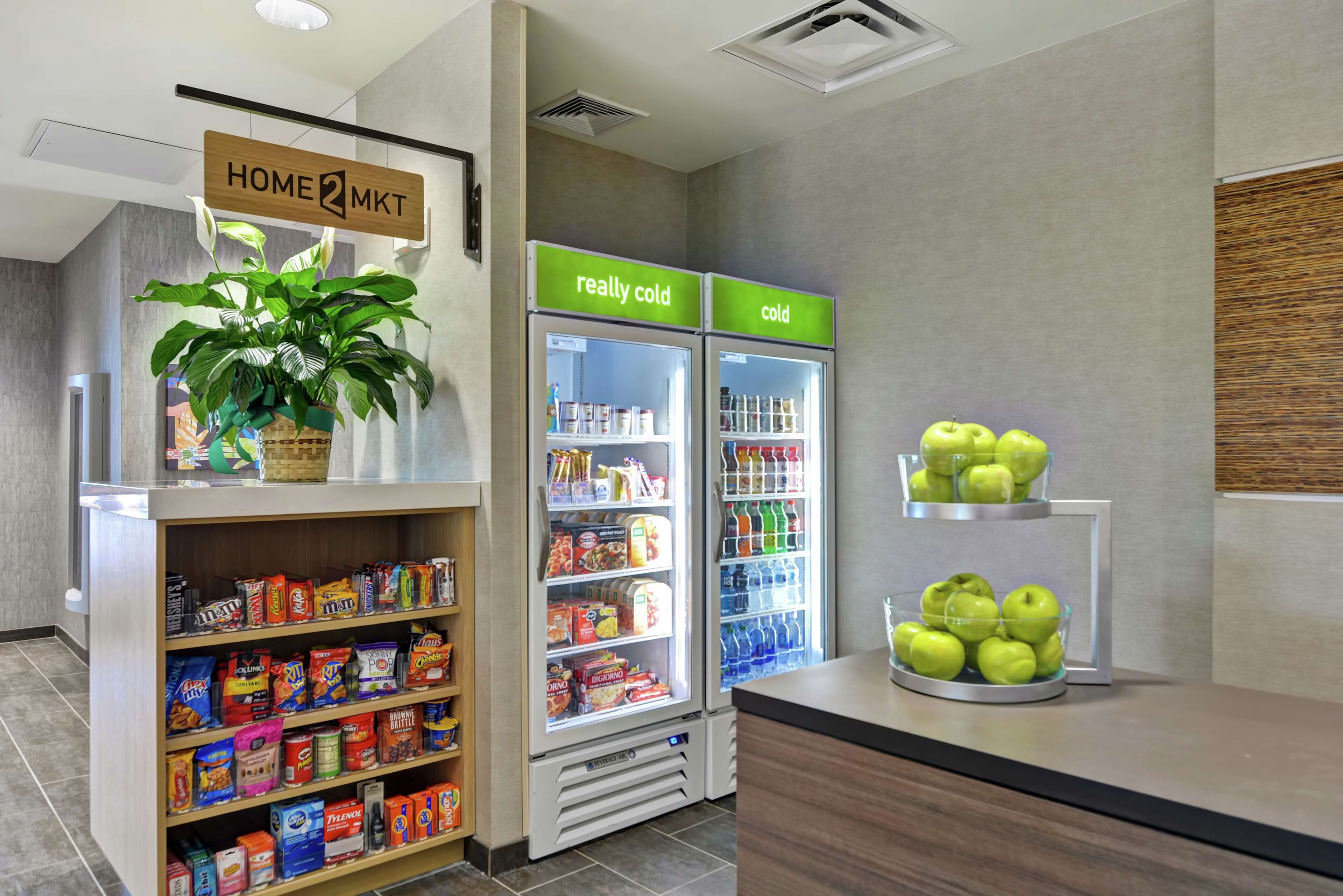 A grocery section with a variety of snacks, a potted plant, and two refrigerators labeled "really cold" and "cold".