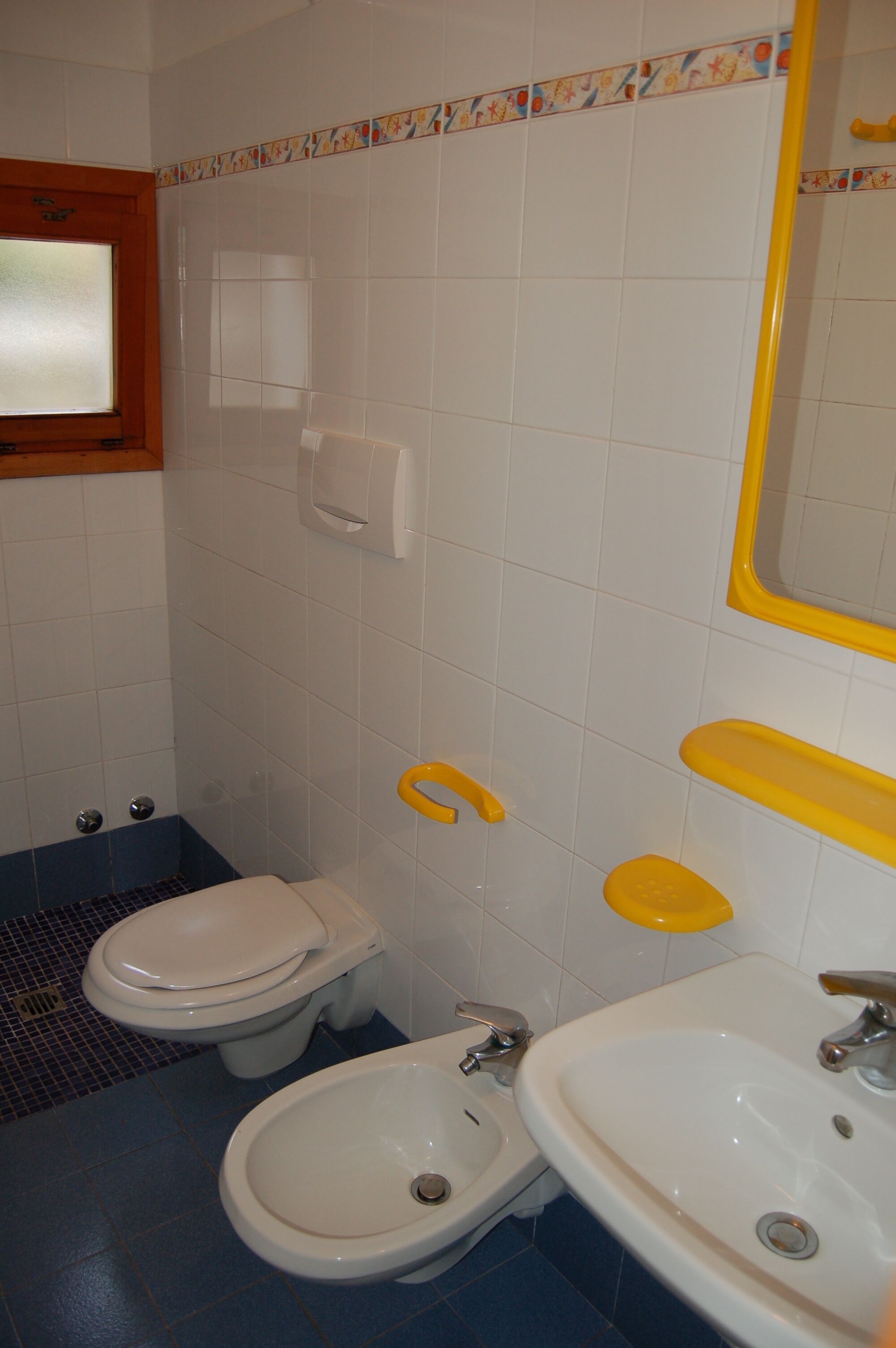 A bathroom with a toilet, bidet, and sink.