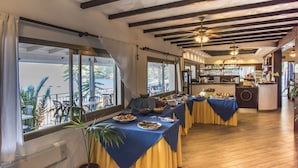 A dining area with tables set for a meal, large windows, and a view of the outdoors. - Villaggio Innamorata - Villa Gisella (Capoliveri)