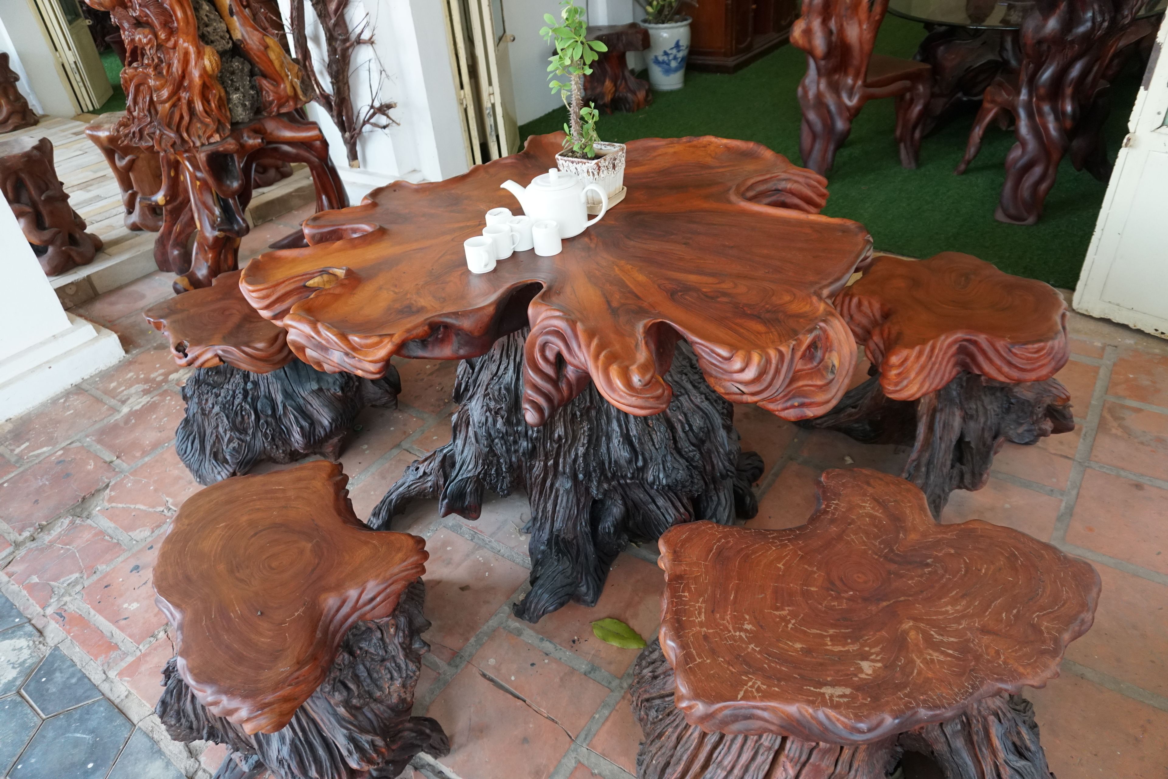 A round wooden table with a unique design, surrounded by matching chairs.