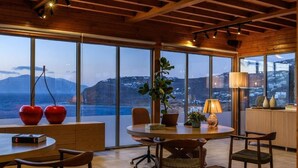 Un comedor moderno con una mesa grande, sillas y vistas al mar.
