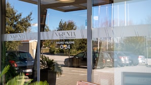 Entrada de un hotel con un letrero que dice "NARENTA HOTEL & RESTAURANT" y "RADNO VRIJEME 024".