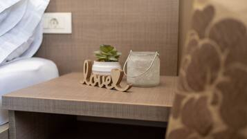A bedside table with a small potted plant, a glass jar with a metal handle, and wooden letters spelling "love".